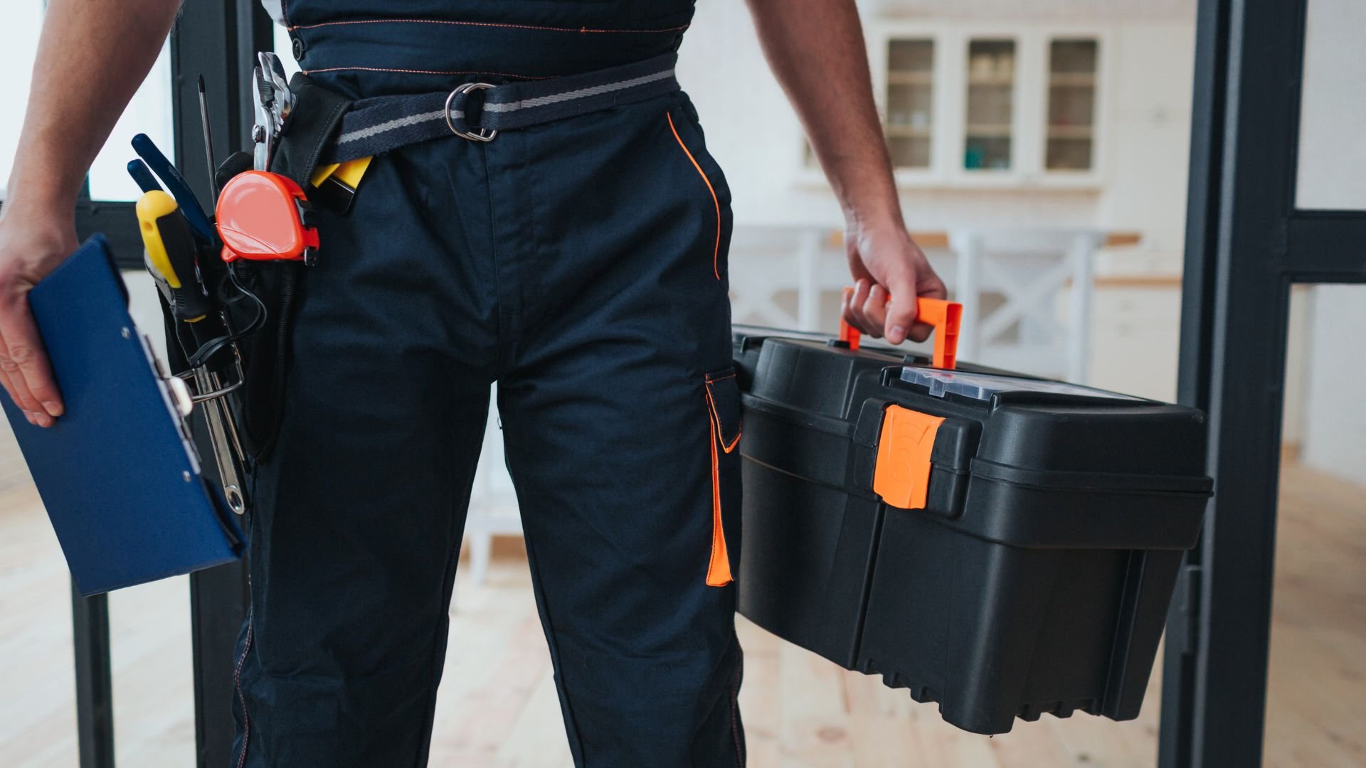 Worker with tool belt and toolbox ready for home repair job